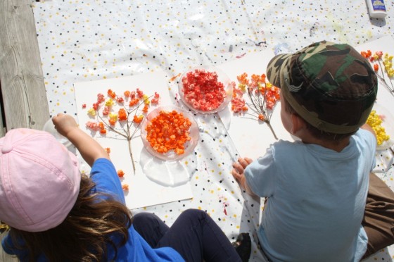 enfants d'âge préscolaire faisant des arbres d'automne avec du popcorn coloré